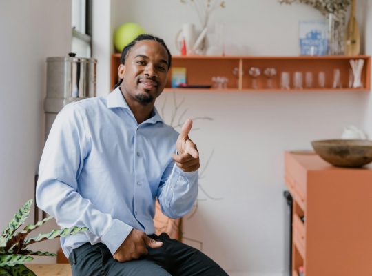 Portrait of Smiling businessman sitting on a desk in an office.