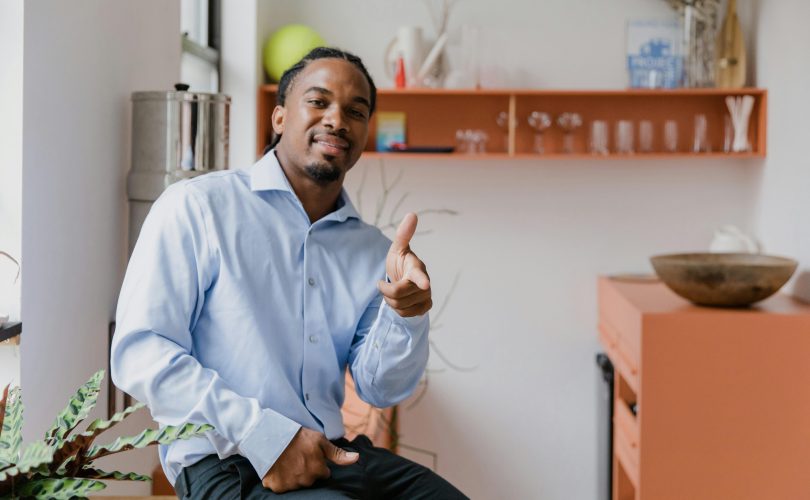 Portrait of Smiling businessman sitting on a desk in an office.