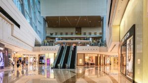 Landscape Image of a large shopping mall with escalators.