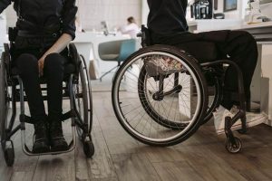 Two people in wheelchairs in the office.