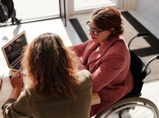 Two people working and using a laptop