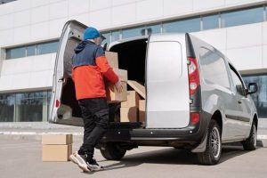 Alt: mover packing moving van with boxes Caption: Avoiding moving scams starts with researching and choosing the right company. Image Credit: https://www.pexels.com/photo/a-man-in-a-jacket-loading-boxes-in-a-van-4391486/