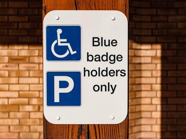 Image Description;: Disability, Wheelchair sign. Image Credit: https://www.pexels.com/photo/information-sign-on-a-wooden-post-11074350/

