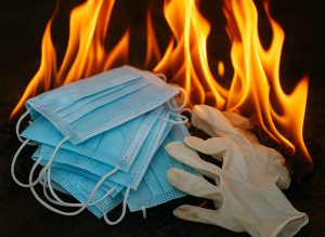 Image Description: A Pile Of PPE Up In Flames. Image Credit: AI-generated illustration created with assistance from ChatGPT (© DisabledEntrepreneur.UK, 2025).