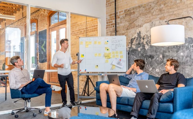 IMAGE DESCRIPTION: three men sitting while using laptops and watching man beside whiteboard. IMAGE CREDIT: https://unsplash.com/@austindistel IMAGE SOURCE: https://unsplash.com/photos/three-men-sitting-while-using-laptops-and-watching-man-beside-whiteboard-wD1LRb9OeEo?utm_source=unsplash&utm_medium=referral&utm_content=creditCopyText