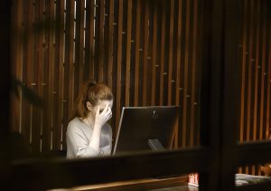 Image Description: A Woman Sitting In Front Of A Desk. Image Source: A woman sitting in front of a laptop computer photo – Free Anxiety Image on Unsplash Image Credit: Vasilis Caravitis (@epicuros) | Unsplash Photo Community