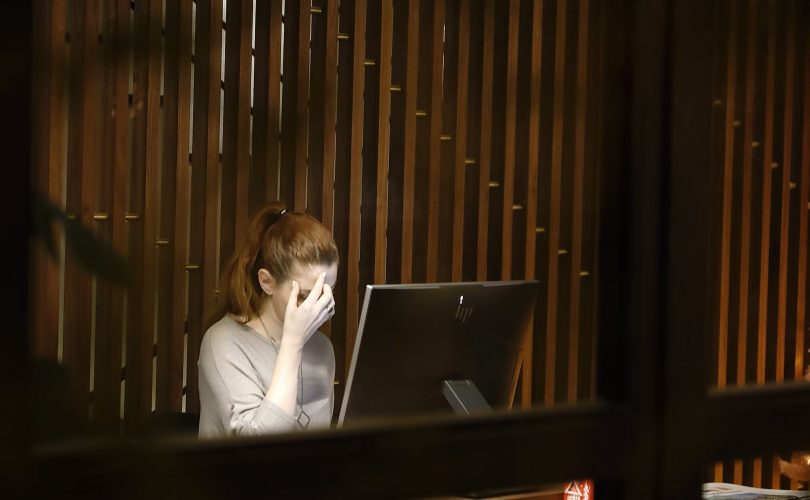 Image Description: A Woman Sitting In Front Of A Desk. Image Source: A woman sitting in front of a laptop computer photo – Free Anxiety Image on Unsplash Image Credit: Vasilis Caravitis (@epicuros) | Unsplash Photo Community