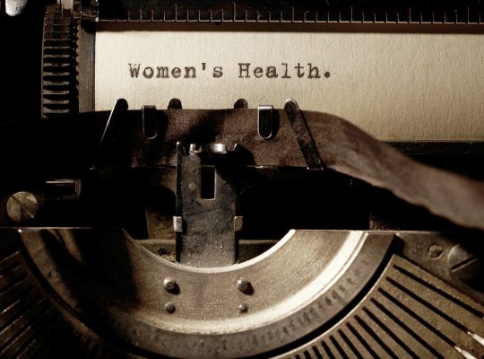 Image Description: Brown & Cream Coloured Image Depicting a Typewriter With Wording "Women's Health". Typed On Paper. Image Credit: PhotoFunia.com Category: Vintage Typewriter.