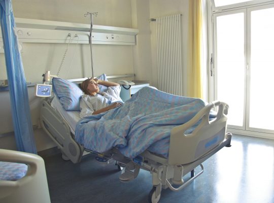 Photo of woman lying in a hospital bed. Image Source: Pexels.com Image Credit: Andrea Piacquadio