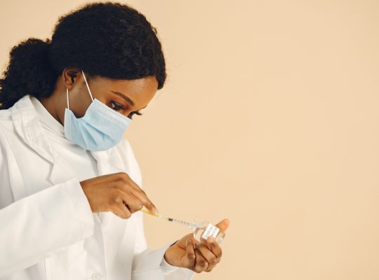 Image Description: Woman In White Lab Gown Holding Syringe Image Credit: Gustavo Fring: https://www.pexels.com/@gustavo-fring/ Image Source: https://www.pexels.com/photo/woman-in-white-lab-gorn-holding-syringe-8770698/